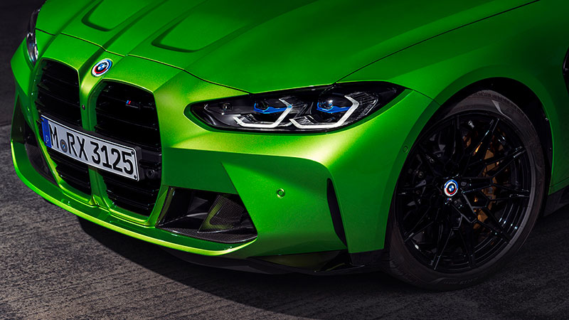 Vediamo la parte anteriore di una BMW M4, di colore verde acceso, con dettagli sportivi