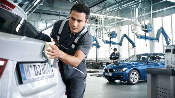 Vediamo un meccanico che sta lucidando il logo posteriore di una BMW