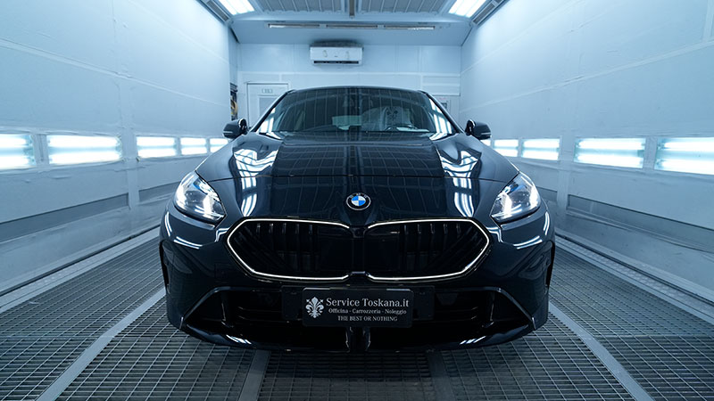 Vediamo una BMW nera all'interno di un'officina Service Toskana